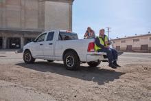 dos trabajadores de construcción están sentados en una camioneta tomándose un descanso del trabajo