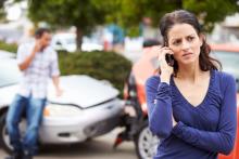 mujer hablando por teléfono tras sufrir un accidente automovilístico