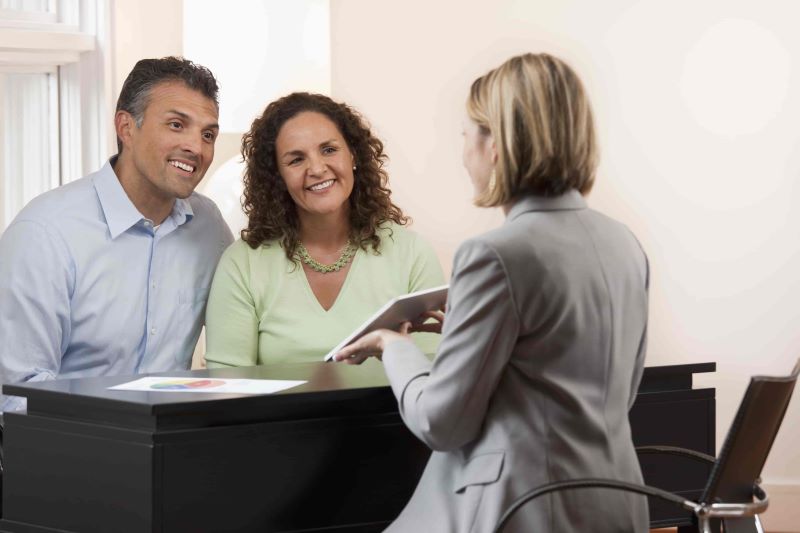 pareja feliz con su agente de seguros