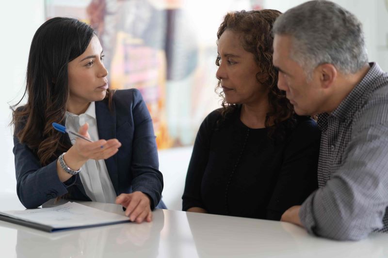 una pareja discutiendo sus opciones de seguro con su agente de seguros