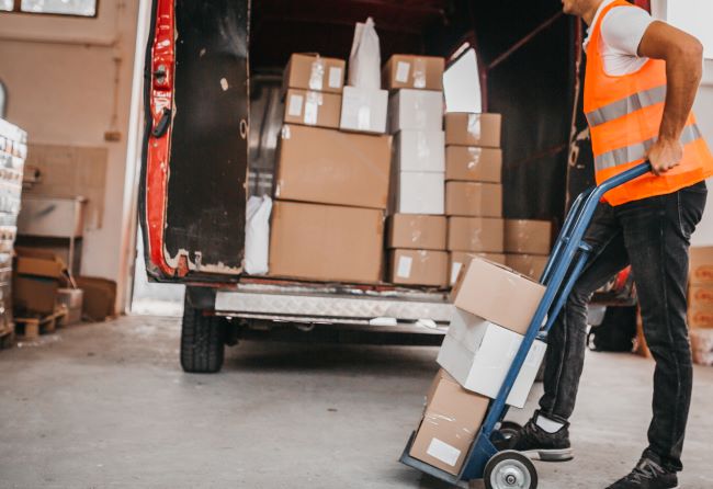 un hombre que usa un carro para sacar cajas de su camion